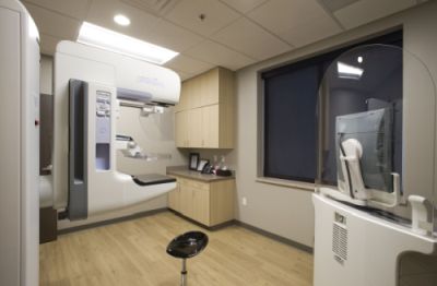 Cozy medical room containing 3D mammogram machine.